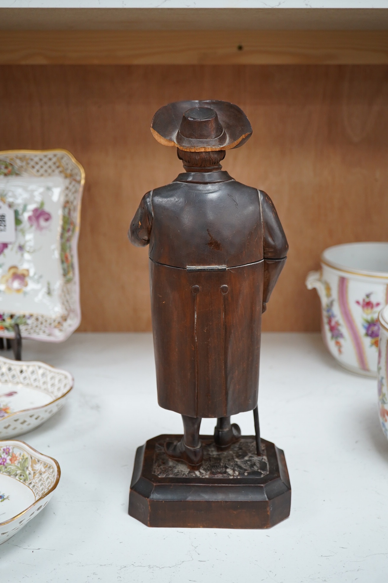 A 19th century Black Forest figure of a gentleman smoking a pipe, hinged at the waist to hold tobacco?, 36.5cm high. Condition - poor to fair, the shaft of his pipe is missing and the rear section of his hat